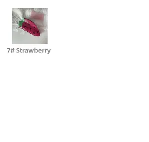 Detail view of strawberry-shaped acrylic hair claw clip with deep pink finish