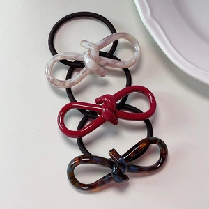 Three-piece acetate hair tie set with marble, red, and tortoiseshell bow designs