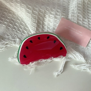 Detail of a watermelon shaped acrylic hair claw clip with vibrant colors and gloss finish