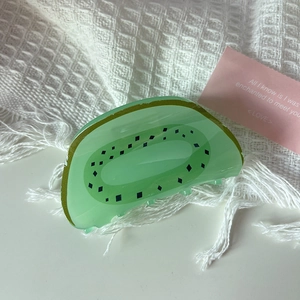 Detail of creative kiwi fruit shaped hair claw clip with transparent green acrylic finish