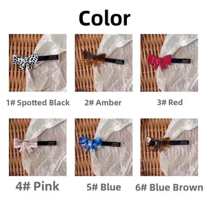 Close-up of six colorful bow hair clips with gold Barrette la France lettering