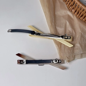 Détail de pinces à cheveux nœuds crème et ambre avec attaches à ressort en métal