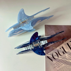 Blue whale hair clips in marble texture and translucent finish on a magazine