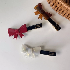 Detail of sweet bow duckbill hair clips with golden Barrette la France logo engraving