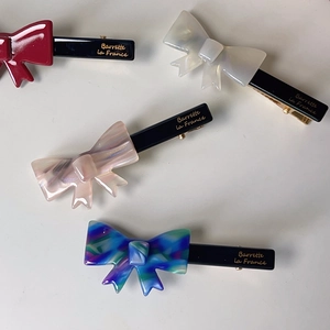 Elegant acetate bow hair clips in four colors with gold branding for girls and women