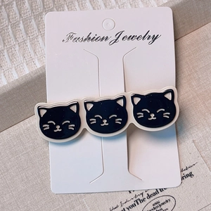 Gros plan de trois breloques chat noir mignonnes sur une barrette en métal élégante