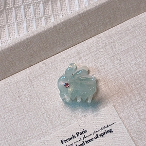 Detail of mint green bunny hair claw with glitter texture and pink rhinestone eye