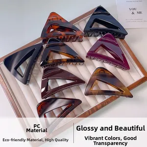 Close-up of triangular PC hair claws in amber and black on a jewelry display tray