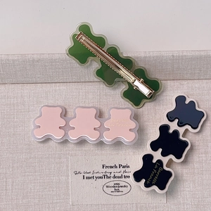 Détail de barrettes panda ondulées en résine acétate verte, rose et bleu marine pour femme