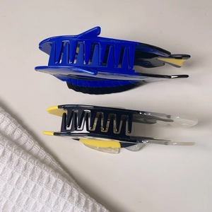 Detail view of two colorful tropical fish hair claws in polished acetate on a soft cloth
