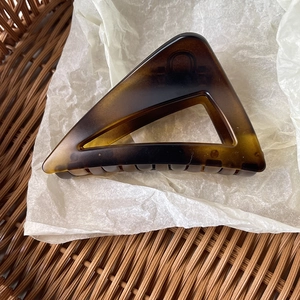 Macro detail of amber tortoiseshell acrylic hair claw clip with cutout triangle design