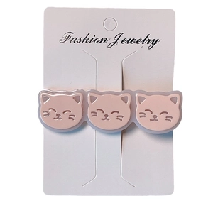 Barrette à cheveux trois chats roses en acétate sur une carte d'affichage