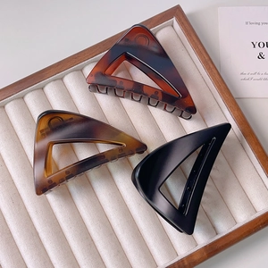 Three-piece set of geometric triangular hair claws in tortoiseshell, amber, and matte black