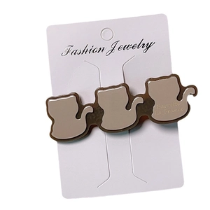 Barrette en acétate chic avec trois silhouettes de chats bruns sur carte à bijoux