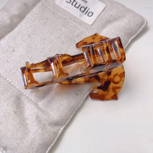 Detailed view of leopard pattern hair claw clip with a glossy acetate finish