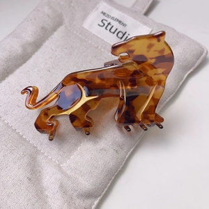 Detailed view of leopard-shaped acetate hair claw with tortoise pattern and gold accents