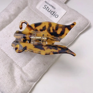 Détail de la pince à cheveux papillon avec motif écaille de tortue et ressort métallique