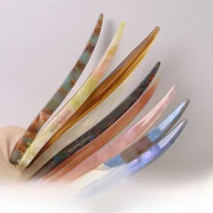 Detailed macro view of assorted acetate hair sticks showing marble texture and handmade mark