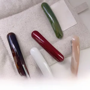 Detail view of five assorted acetate spring hair clips with smooth polished finish