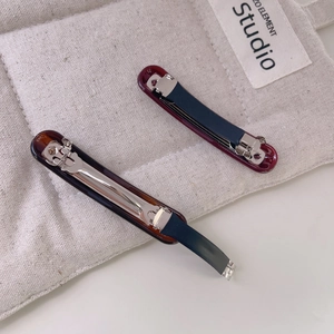 Elegant curved acetate hair clip set in burgundy and tortoiseshell on canvas background