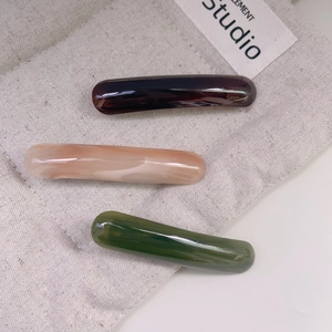 Three-piece acetate hair clip set in tortoise, pink marble, and forest green colors