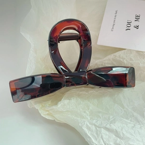 Detailed view of 13cm oversized bow claw clip with elegant dark tortoiseshell pattern