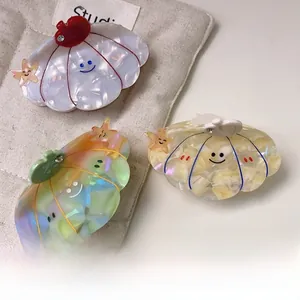 Detailed macro view of shell-shaped acetate hair claws with starfish and glitter charms