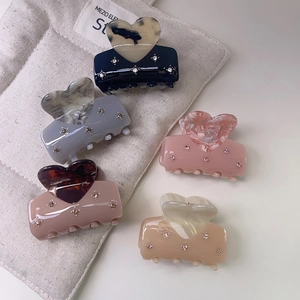 Five assorted heart-shaped acetate hair claws with sparkling rhinestones for women