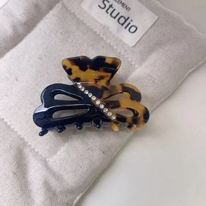 Macro view of butterfly acetate hair claw with rhinestones and tortoise pattern