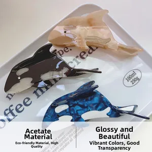 Detailed view of eco-friendly acetate hair claws with marble whale and dolphin patterns