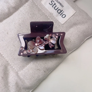 Detail view of purple acetate hair claw clip with gradient floral rhinestones