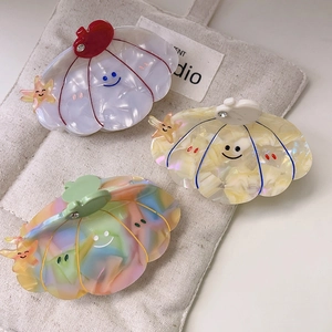 Cute acetate shell hair claws with smiling starfish details and pearlescent marble finish