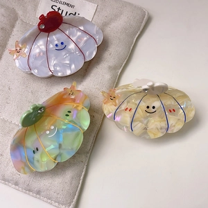 Set of three cute shell-shaped hair claws with smile faces and starfish in various colors