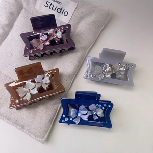 Set of four glossy acetate hair claws with rhinestone floral accents in premium colors