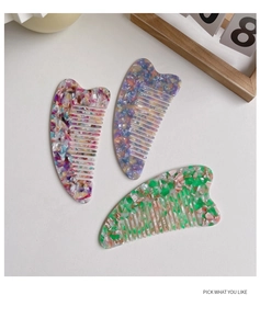 Close-up of three colorful acetate hair combs with floral patterns and smooth teeth