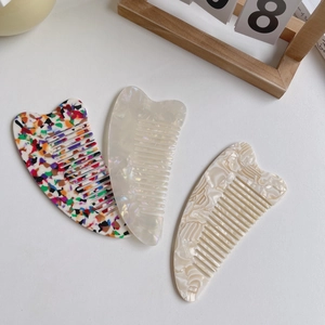 Three elegant acetate cellulose hair combs in heart shapes with marble and pearl patterns