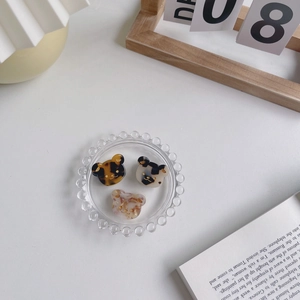 Lot de trois pinces à cheveux ours en acétate aux motifs léopard et floral sur plateau