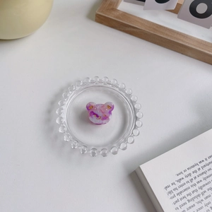 Détail de la pince à cheveux en forme d'ours en acétate marbré rose sur verre
