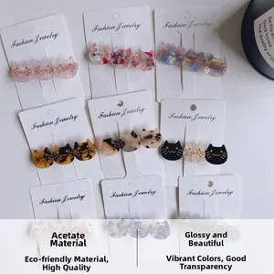 Detailed close-up of cat-shaped acetate hair clips in leopard and pastel patterns