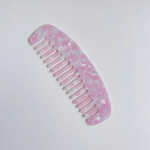 Dettaglio del pettine in acetato di cellulosa con motivo marmo rosa e denti tondi