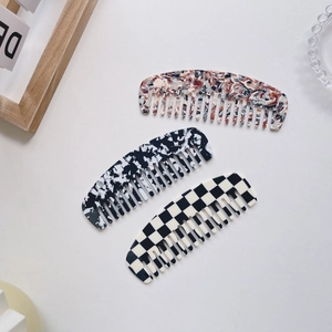 Dettaglio di pettini in acetato con motivi ambra, marmo e scacchiera alla moda