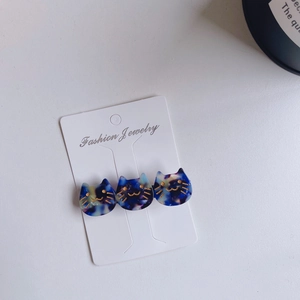 Three cat-shaped acetate hair clips with marble texture on a fashion jewelry display card