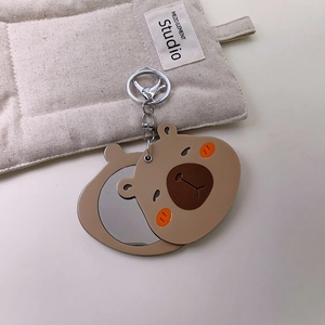 Close-up of cute khaki bear shaped portable keychain mirror with silver spring clip