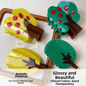Close-up of fruit tree acetate hair claws in yellow and green on a wooden tray