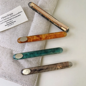 Set of four vintage acetate hair clips in amber, emerald green, and leopard print colors