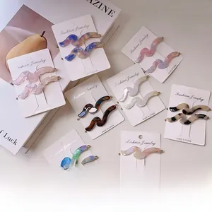 Close-up of wavy acetate hair pins in marble patterns on elegant jewelry display card