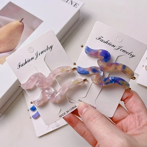 French retro wavy acetate hair clips in pink and purple marble pattern on display card