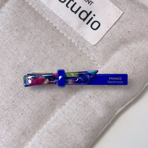 Detail of blue acetate hair clip with floral pattern and France Handmade text
