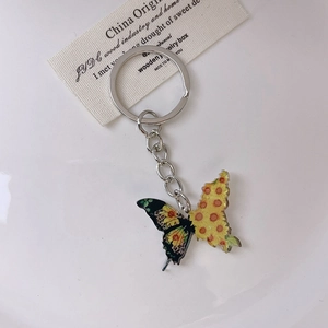 Creative butterfly keychain with artistic asymmetric wings on an elegant display tray