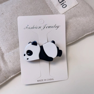 Gros plan détaillé d'une pince à cheveux panda mignon sur carte Fashion Jewelry blanche